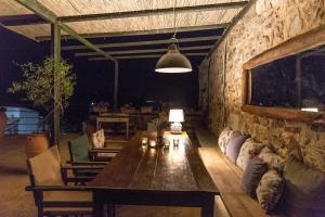 a living room with a table and a stone wall at Orgon Farm Traditional Houses in Apóstoloi +45 photos