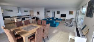 Una sala de estar con una mesa y un sofá azul. en Villa de standing piscine chauffée vue mer Corse du sud, en Coti-Chiavari