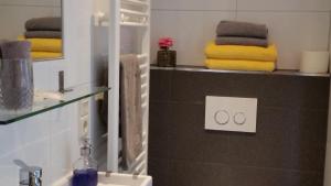 a bathroom with a sink and towels on a shelf at 't KISTJE Bed by the Sea in Koudekerke +17 photos