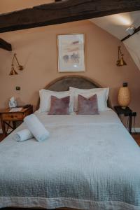 a bedroom with a large bed with white pillows at Rose & Star Cottage in Frome