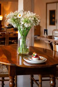 a vase of flowers and a plate of food on a table at Hôtel du Grand Capelet in Belvédère