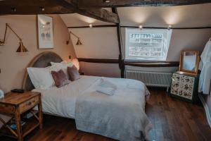 a bedroom with two beds and a table and a window at Rose & Star Cottage in Frome