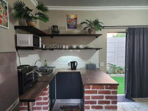 a kitchen with a stove and a brick fireplace at Ode to Serenity Cottage in Pretoria