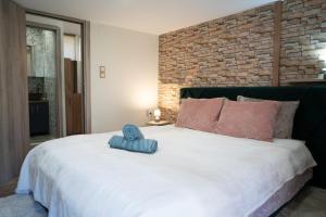 a bedroom with a large white bed with a brick wall at Tzànnou farm residence in Mytilene