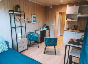 a room with a bed and a kitchen with a desk and chairs at La chambre des oliviers in Aubais +19 photos