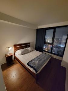 een slaapkamer met een bed en 2 grote ramen bij Dream Apartment in Longueuil +14 foto's