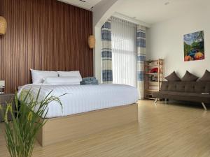 芹苴Experience Homestay的带一张大床和一张沙发的卧室