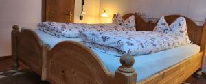 a wooden bed with pillows on top of it at Ferienwohnungen JoJaSa in Laces