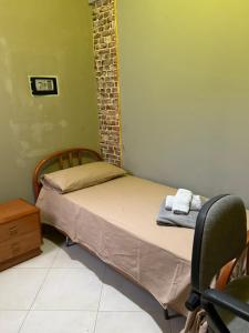 ein kleines Schlafzimmer mit einem Bett und einem Stuhl in der Unterkunft frizzi house in Parabita