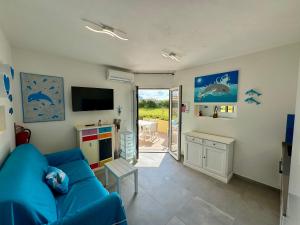 a living room with a blue couch and a television at Appartamenti delfini terza spiaggia in Golfo Aranci