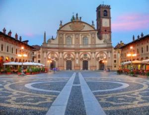 a large building with a clock tower in a courtyard at Dolce Dormire in Vigevano