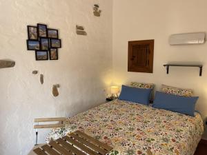 a bedroom with a bed with blue pillows and a bench at B&B Sol y Monte in Alora +67 photos