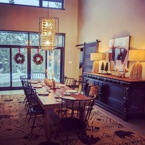 una sala da pranzo con tavolo, sedie e lampadario di Chalet Hill Top Inn a Messines