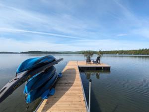 un molo con due barche su un lago di Chalet Hill Top Inn a Messines Altre 92 foto