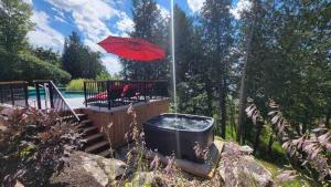 patio con vasca idromassaggio e ombrellone di Chalet Hill Top Inn a Messines