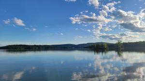 un grande bacino d'acqua con alberi e nuvole di Chalet Hill Top Inn a Messines