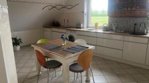 a kitchen with a wooden table and four chairs at Experience peace and quiet enjoy space in Münster