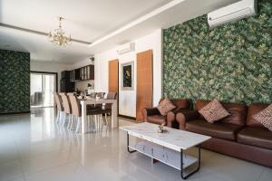 a living room with a couch and a table at Queen Massarossa Pool Villa Pattaya-25 in Pattaya Central