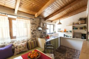 a kitchen with a table with a bowl of fruit on it at Orgon Farm Village Houses in Apóstoloi