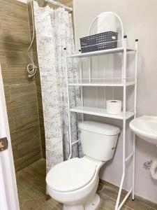 une salle de bain avec des toilettes blanches et un lavabo dans l'établissement Apartamento Moderno y Privado, à Santa Ana