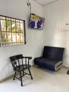 Cette chambre comprend un canapé, une chaise et une fenêtre. dans l'établissement Apartamento Moderno y Privado, à Santa Ana