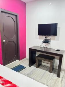 a room with a desk with a television and a door at SRI Surya Guest House in Visakhapatnam