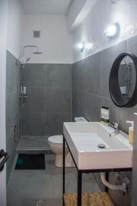 a bathroom with a sink and a toilet and a mirror at mandala central apartment in Rhodes Town