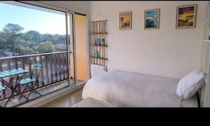 a bedroom with a bed and a balcony with a view at Studio les mouettes in Mimizan-Plage