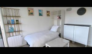 a bedroom with a bed and a clock on the wall at Studio les mouettes in Mimizan-Plage