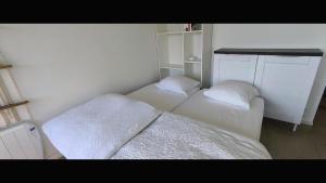two beds in a small room with white walls at Studio les mouettes in Mimizan-Plage +8 photos