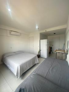 a bedroom with two beds and a refrigerator at Apartamento Estúdio in Teresina