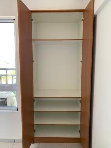 a closet with wooden shelves and a window at Apartamento Estúdio in Teresina