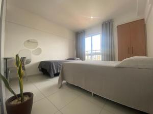a bedroom with a large bed and a potted plant at Apartamento Estúdio in Teresina