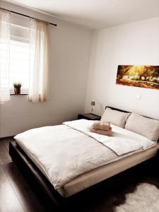 a bedroom with a large white bed with a painting on the wall at Casa Bruno in Vodnjan