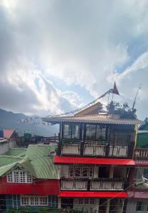 a building with a balcony on top of it at Subba Homestay Sukhia Pokhari Ramjee Road in Sukhia Pokhari