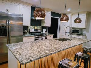 a kitchen with white cabinets and a granite counter top at Arcade Shuffleboard Poker Firepit Grill @ Battery in Marietta