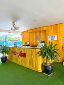 a reception counter in a room with a palm tree at Vang Vieng Golden Dragon House in Vang Vieng +63 photos
