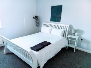 a white bedroom with a white bed with two pillows at Cosy and warm Belfast Central 2 Beds Apartment in Belfast