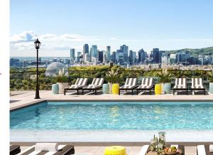 a swimming pool with lounge chairs and a city skyline at Dream Apartment in Longueuil