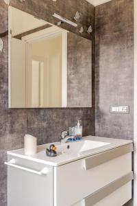Un baño con un lavabo blanco y un espejo. en Garda Art&Lake, en Peschiera del Garda