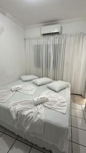 a white bed with white sheets and pillows on it at Pousada Iracema Centro in Fortaleza +215 photos