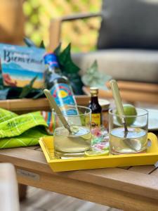 a tray with two glasses and spoons on a table at Chill Out, bungalow ensoleillé in Grand-Bourg