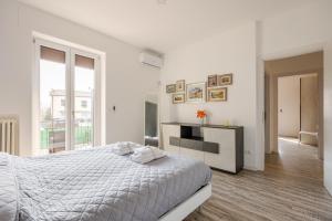 Un dormitorio blanco con una cama y una chimenea. en Garda Art&Lake, en Peschiera del Garda