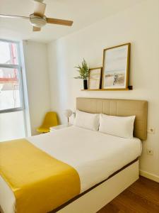 sypialnia z dużym łóżkiem i żółtym kocem w obiekcie LUMINOSO APARTAMENTO en el centro de Cádiz w Kadyksie