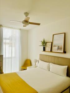 sypialnia z łóżkiem i wentylatorem sufitowym w obiekcie LUMINOSO APARTAMENTO en el centro de Cádiz w Kadyksie