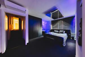 a bedroom with a bed and a purple light at Midnight Old Town in Bydgoszcz
