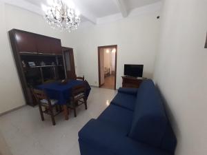 a living room with a blue couch and a table at A Due Passi da MicheIino in Parghelia
