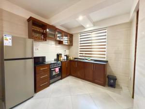 a small kitchen with a refrigerator and a sink at Comfort Retreat 2 in Dar es Salaam
