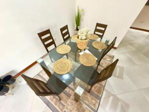 a dining room table with chairs and a glass table with at Comfort Retreat 2 in Dar es Salaam
