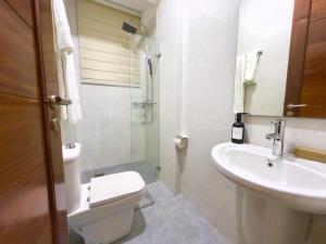 a white bathroom with a toilet and a sink at Comfort Retreat 2 in Dar es Salaam